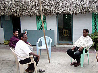 View larger image men seated in courtyard